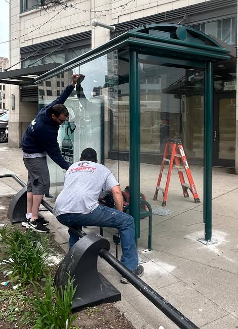 Workers installing a downtown bus shelter